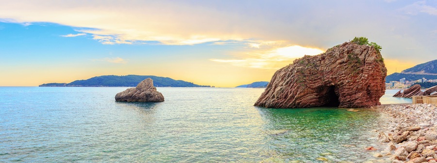 Sunset on the Adriatic sea near Budva city in Montenegro, gorgeous seascape with big rock in the beach