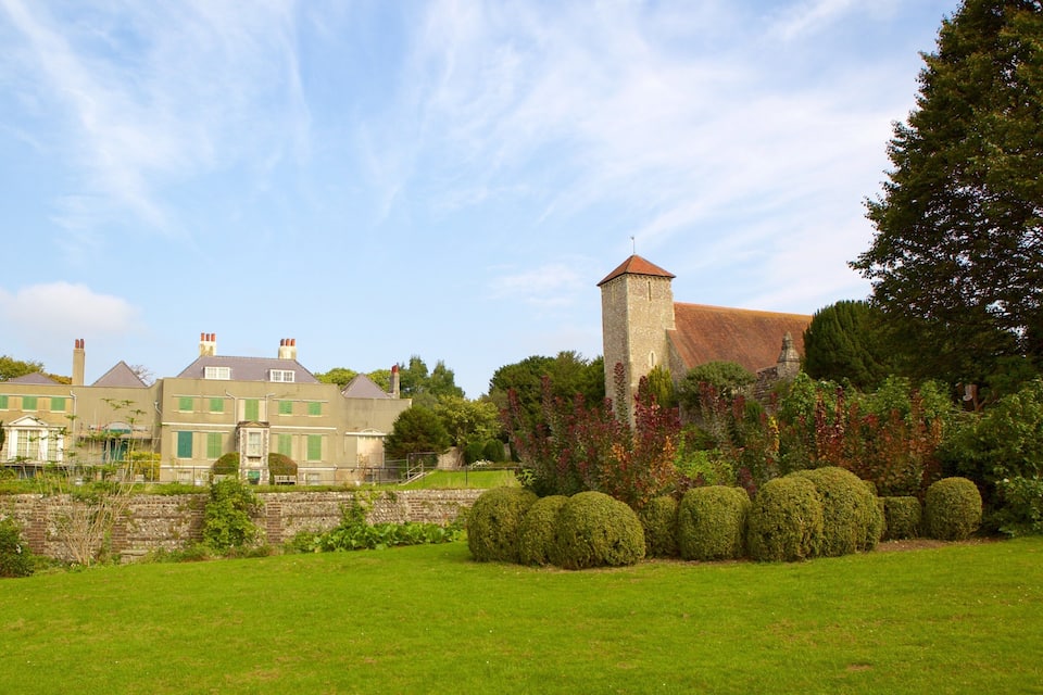 A large estate with a prominent tower, lush green lawns, and mature trees.
