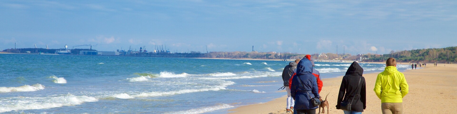 Praia Jelitkowo caracterizando uma praia assim como um pequeno grupo de pessoas