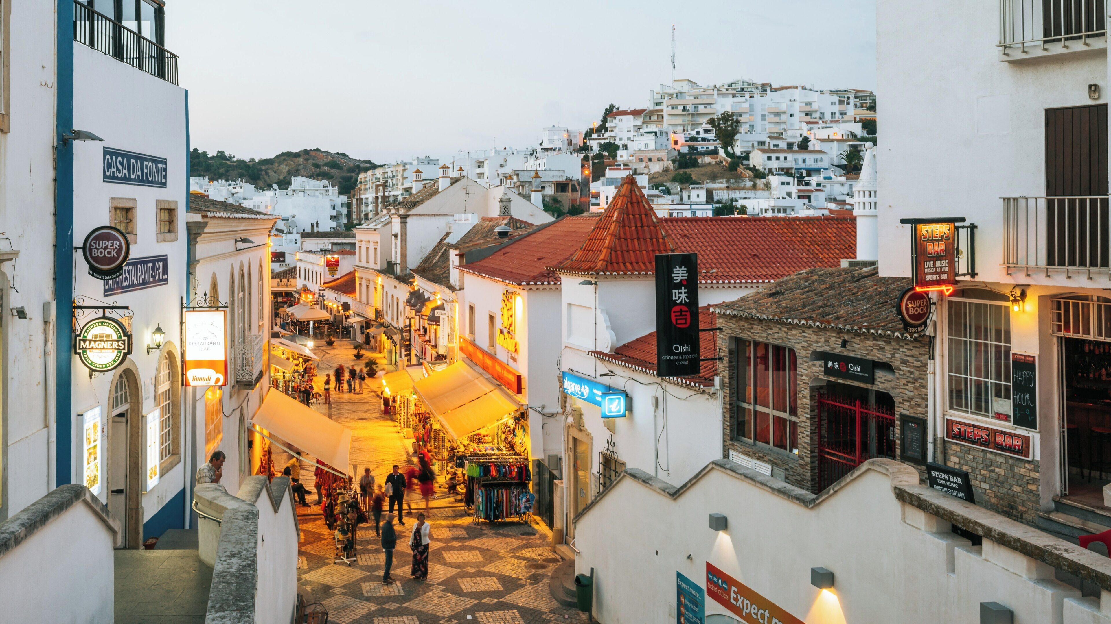 Explore Albufeira Old Town Square during sunset in Faro District, Portugal, where vibrant life meets historical charm amid the bustling streets