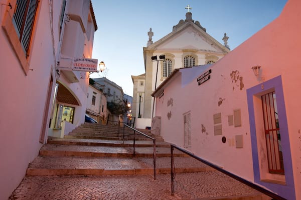 Une rue pavée menant à une église dotée d’un clocher.