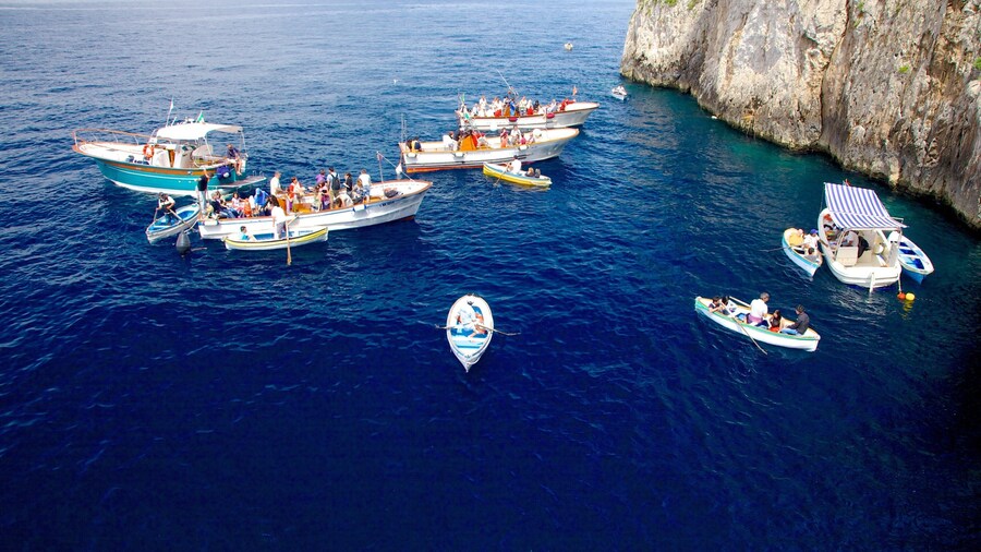 Blue Grotto which includes rugged coastline and boating as well as a small group of people