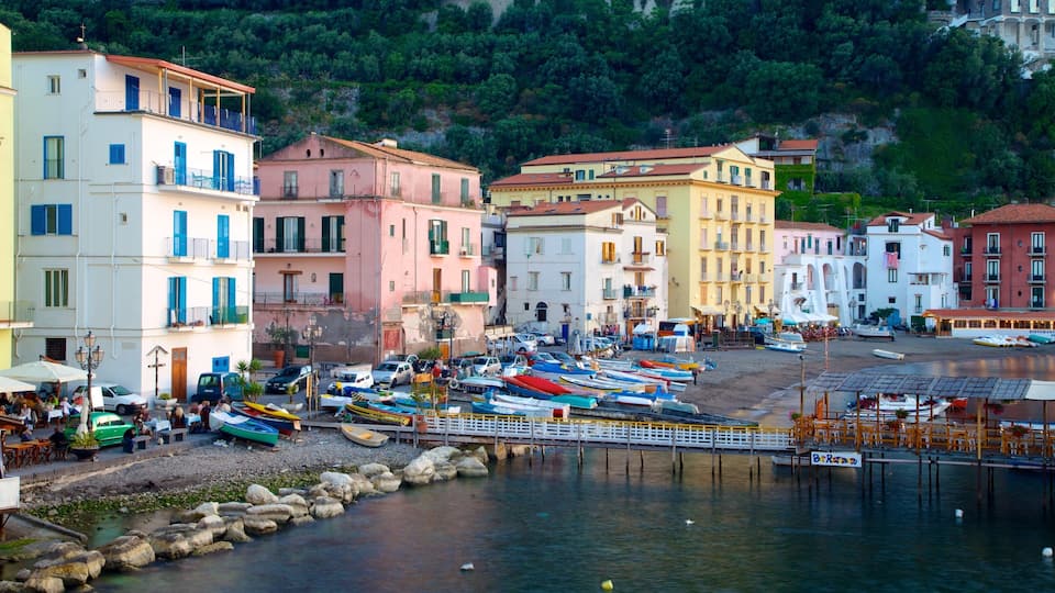 A coastal town with colorful buildings, a marina with boats, and a rocky shoreline.
