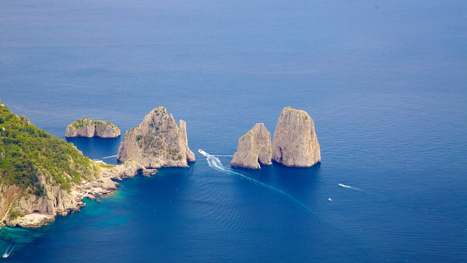 A coastal landscape with rocky formations and clear blue waters.