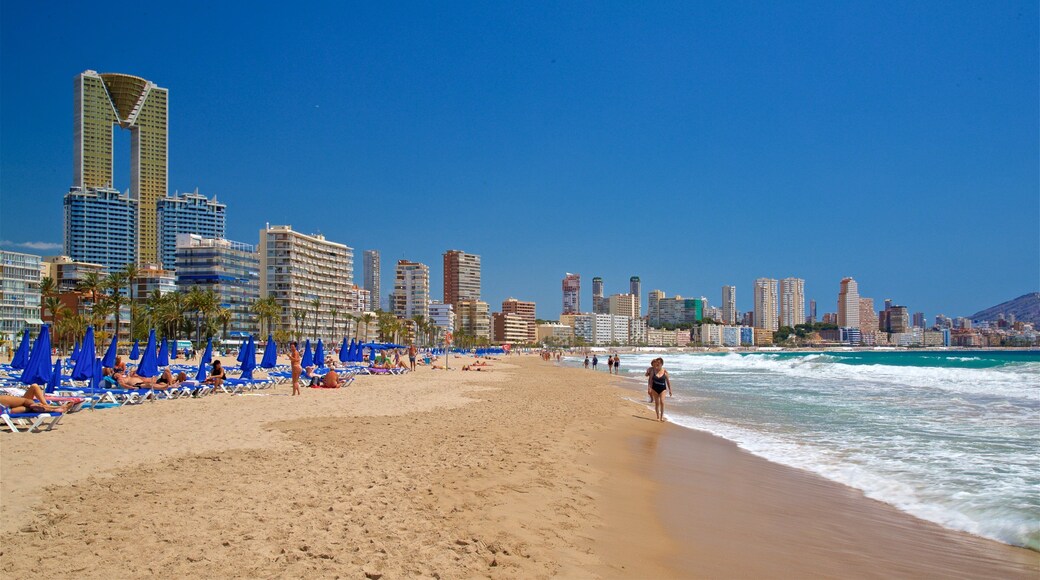 Poniente Beach which includes a coastal town, a beach and general coastal views