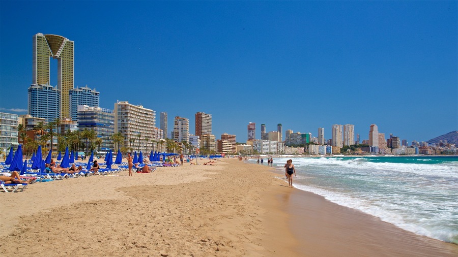 Poniente Beach which includes a coastal town, a beach and general coastal views