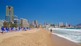 Poniente Beach which includes a coastal town, a beach and general coastal views
