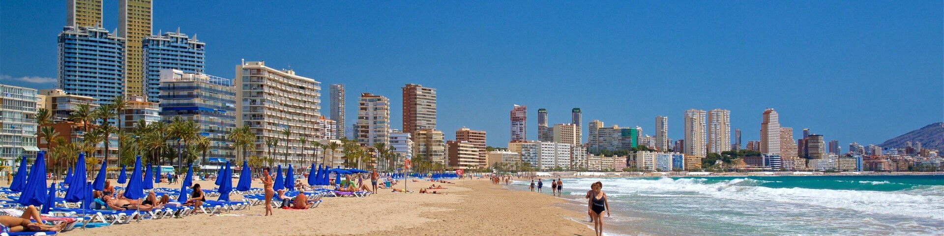 Poniente Beach which includes a coastal town, a beach and general coastal views