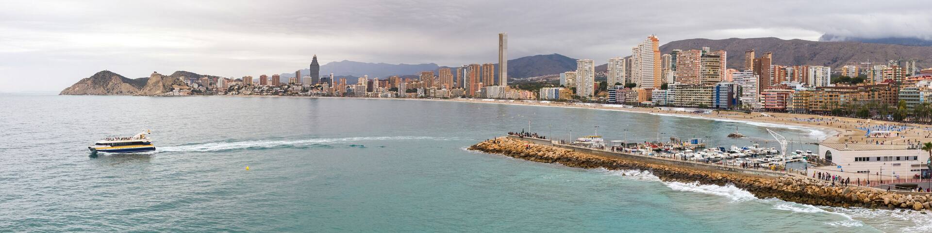 Panoramic view of the Poniente beach in Benidorm with its skyscrapers facing the sea from the Balcon del Mediterraneo and tourist boat