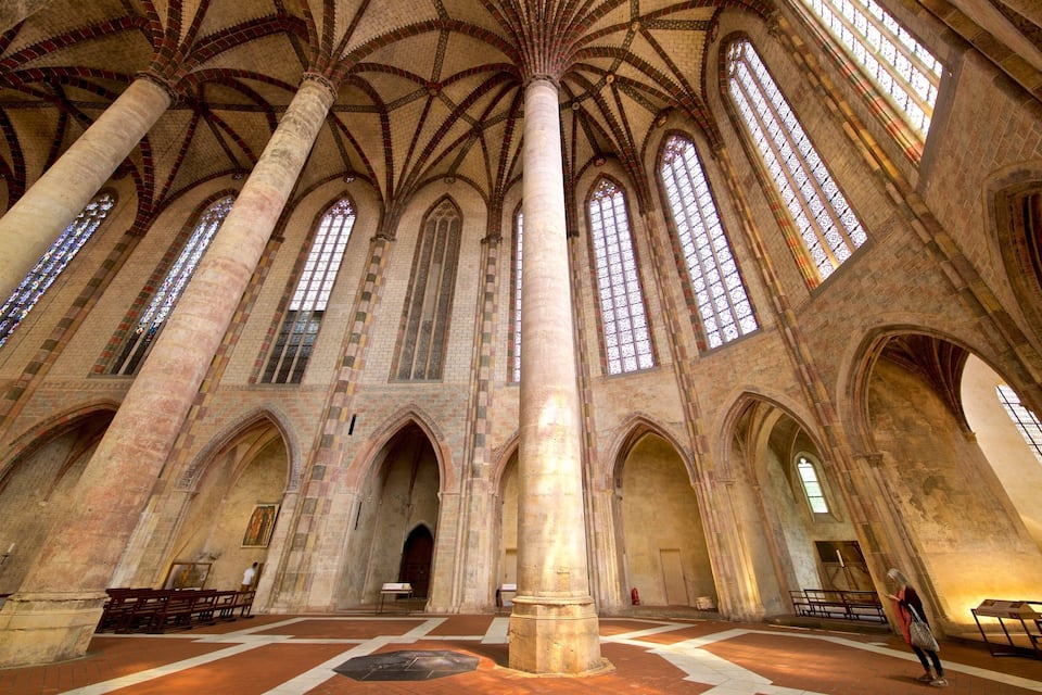 Ein gotischer Dom mit hohen Gewölbedecken, großen Buntglasfenstern und einer zentralen Apsis.