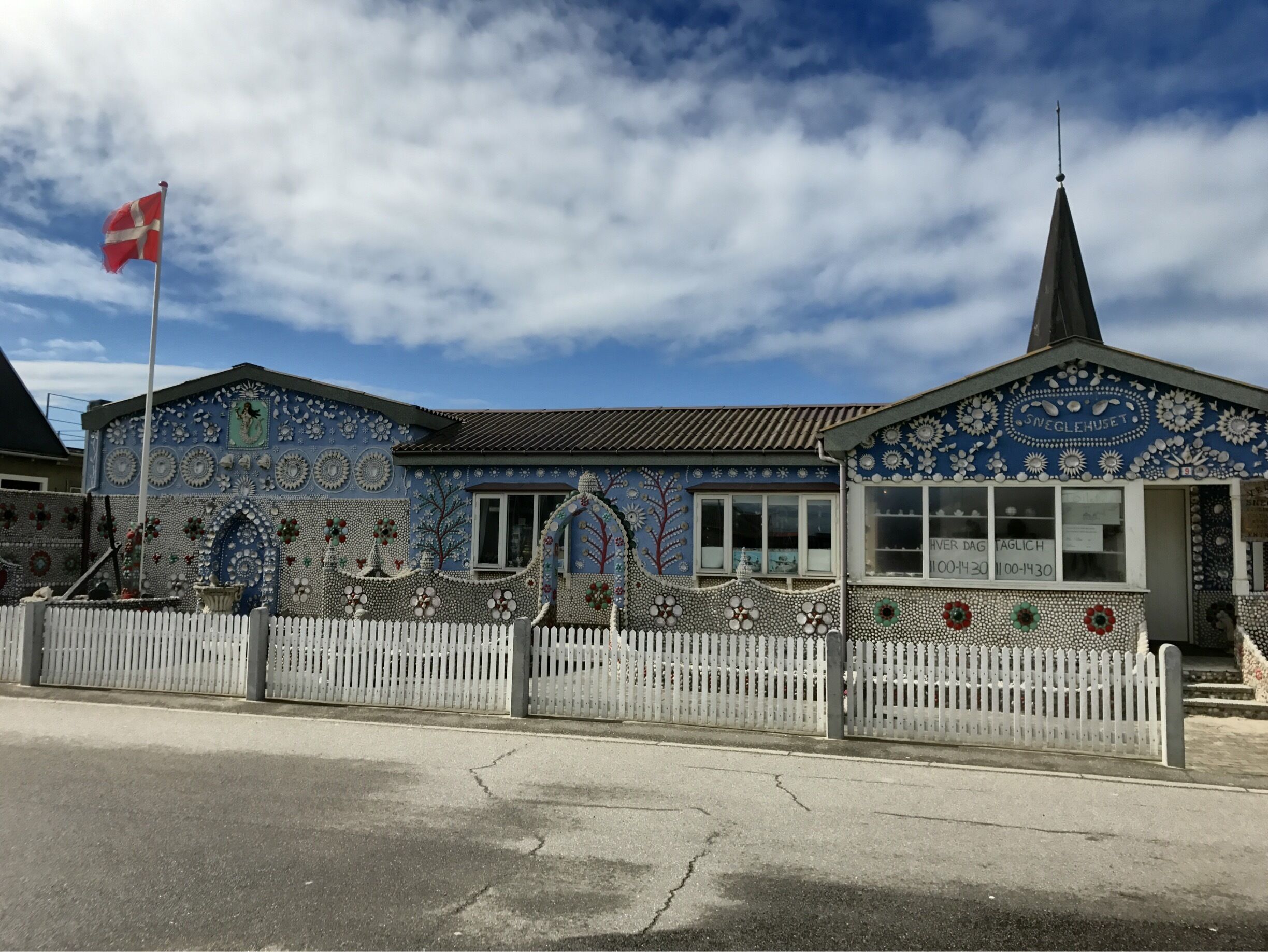 A building with intricate mosaic tilework and a flagpole with a flag.