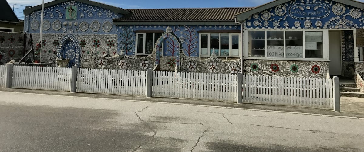 A building with intricate mosaic tilework and a flagpole with a flag.