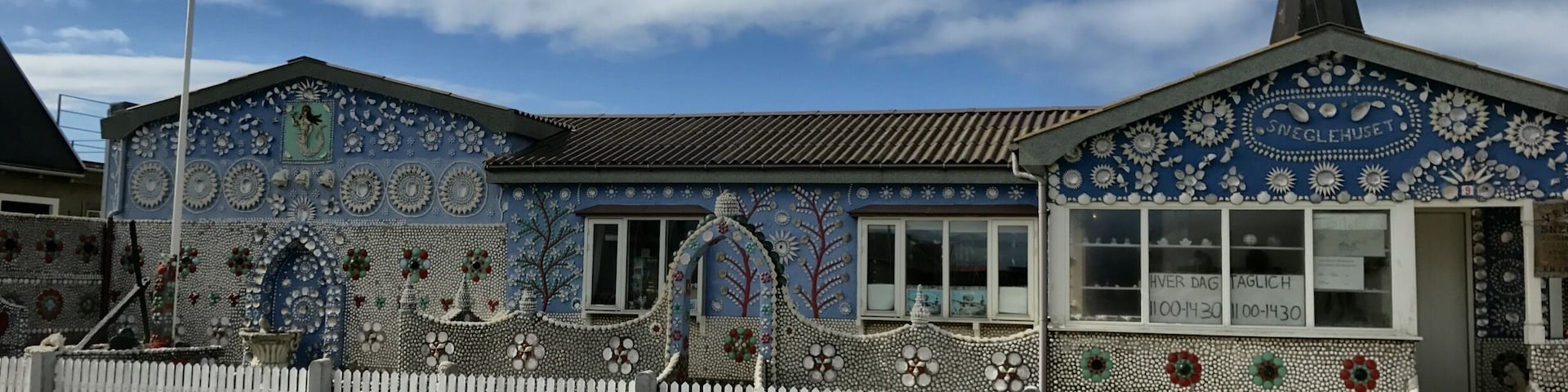 A building with intricate mosaic tilework and a flagpole with a flag.