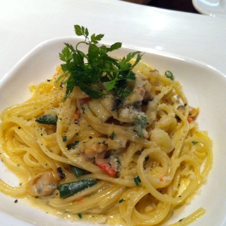 A plate of spaghetti with a creamy sauce, garnished with parsley.