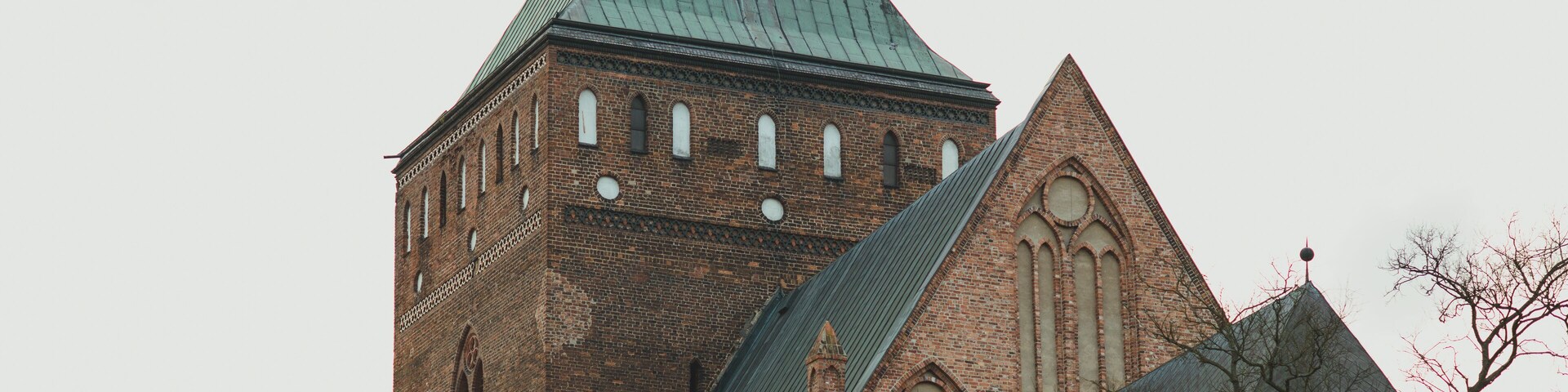 A church with a steeply pitched roof and a cross on top.