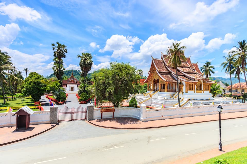 A temple complex with traditional architecture, a gate, and a well-maintained garden.