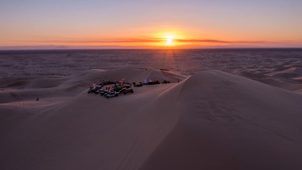 Sunset Over Desert Sand Dunes with Vehicles at Algodones