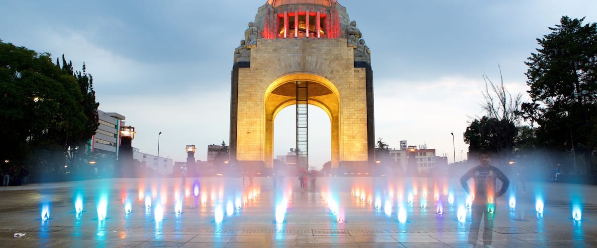 Monumento a la Revolución mostrando elementos del patrimonio, escenas nocturnas y un parque o plaza