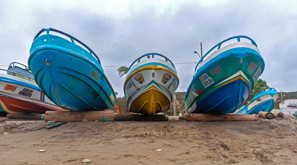 Low and wide angle view of several boats on the beach sand, on logs, on an overcast morning. Puerto Cayo, Manabi, Ecuador