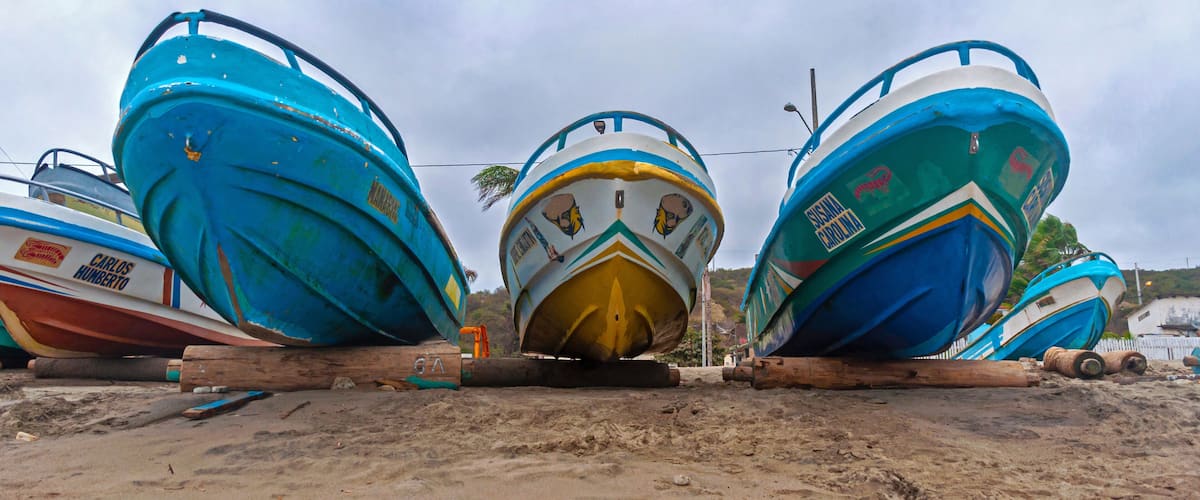 Several boats tied up on a sandy beach.