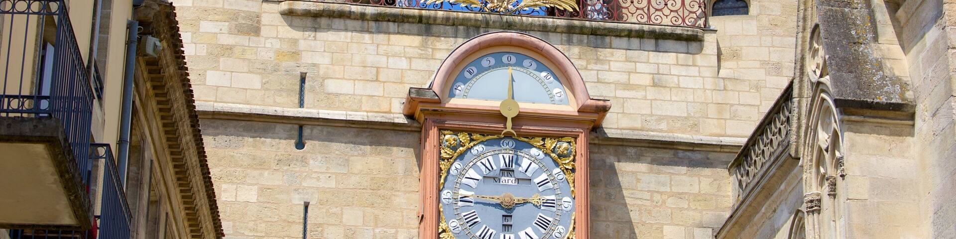 A historic clock tower with a large bell and ornate decorations.