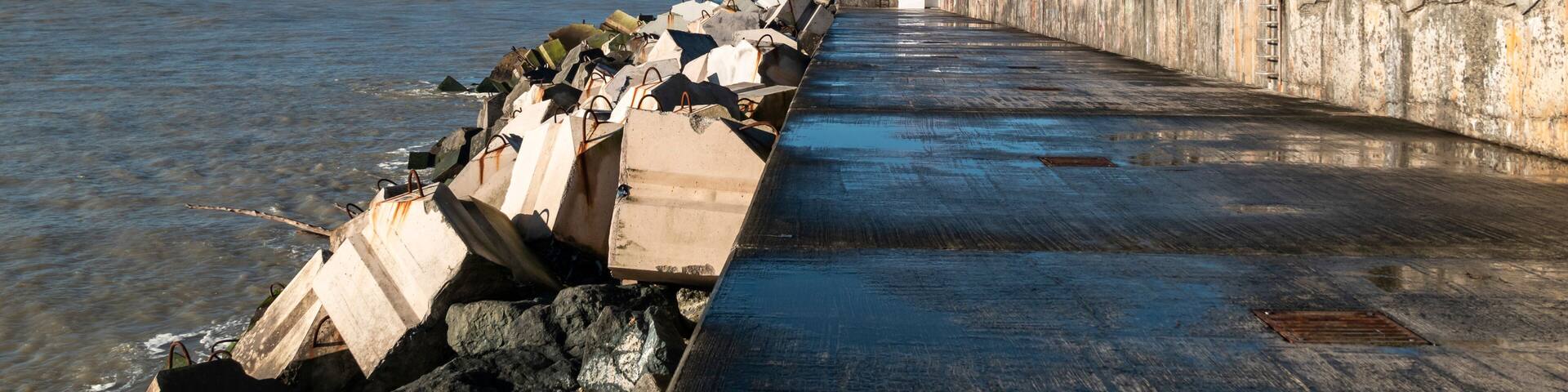 Dique da praia de Dique em Boucau com um farol ao fundo