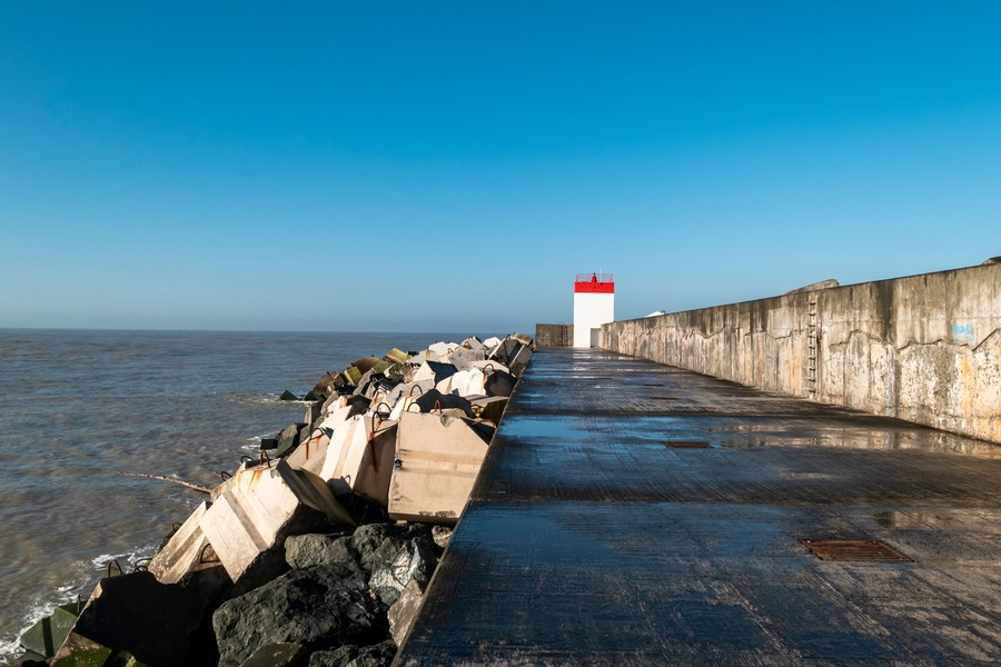 Dique da praia de Dique em Boucau com um farol ao fundo