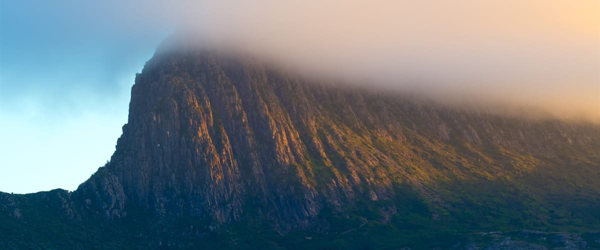 Binnenland das einen Sonnenuntergang, Berge und Nebel
