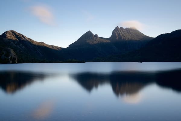 A calm lake with mountains in the background.