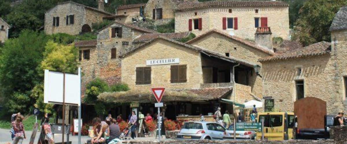 A historic town with a prominent castle in the background, cobblestone streets, and a sign for a local bakery.