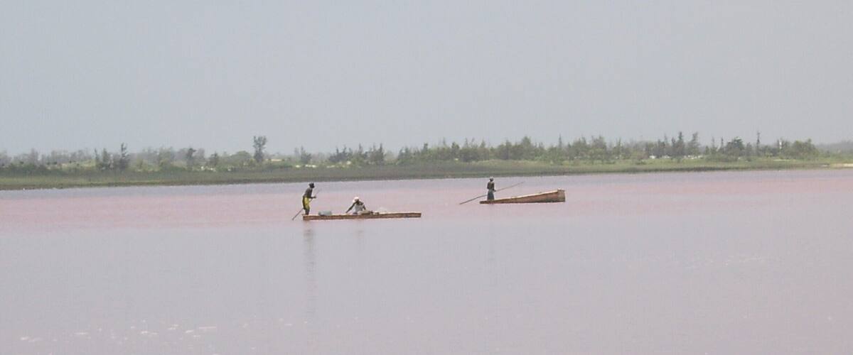 Two boats on a calm river with a forested shoreline.