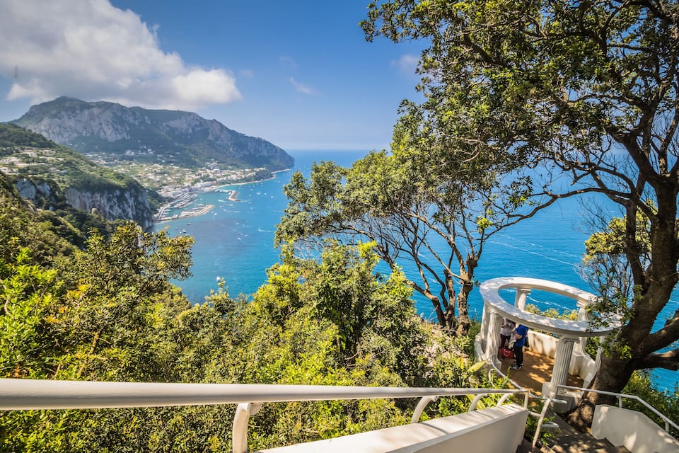 A coastal landscape with a view of the sea, cliffs, and a gazebo.
