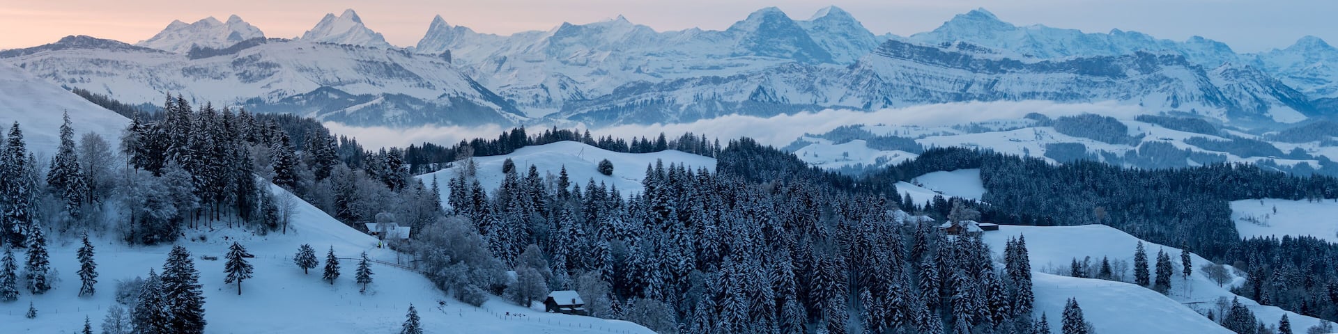 panoramic view on a beautiful winter sunrise in snowy Emmental
