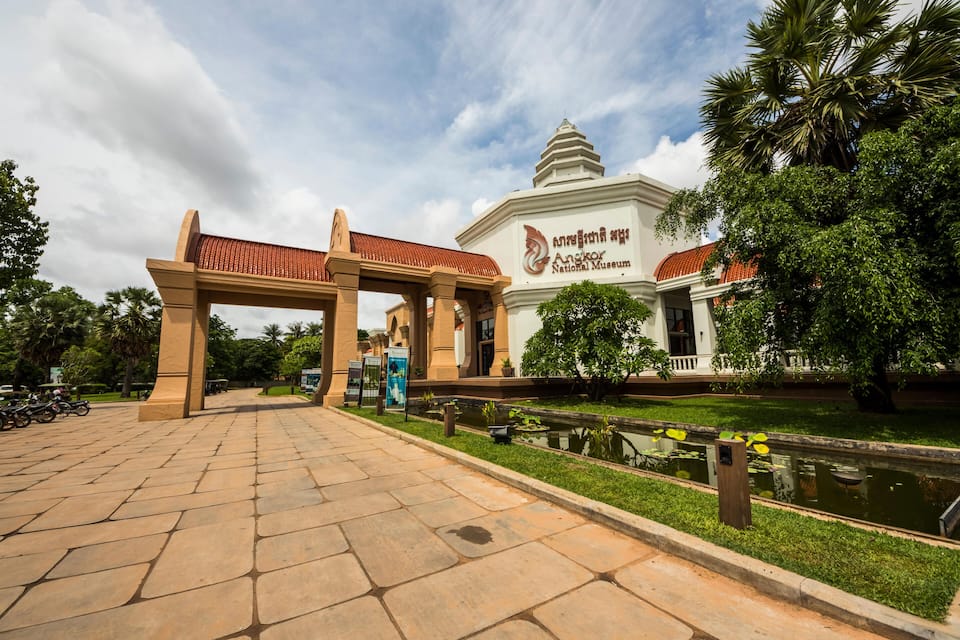The entrance to the Angkor National Museum with a traditional archway and a pond.