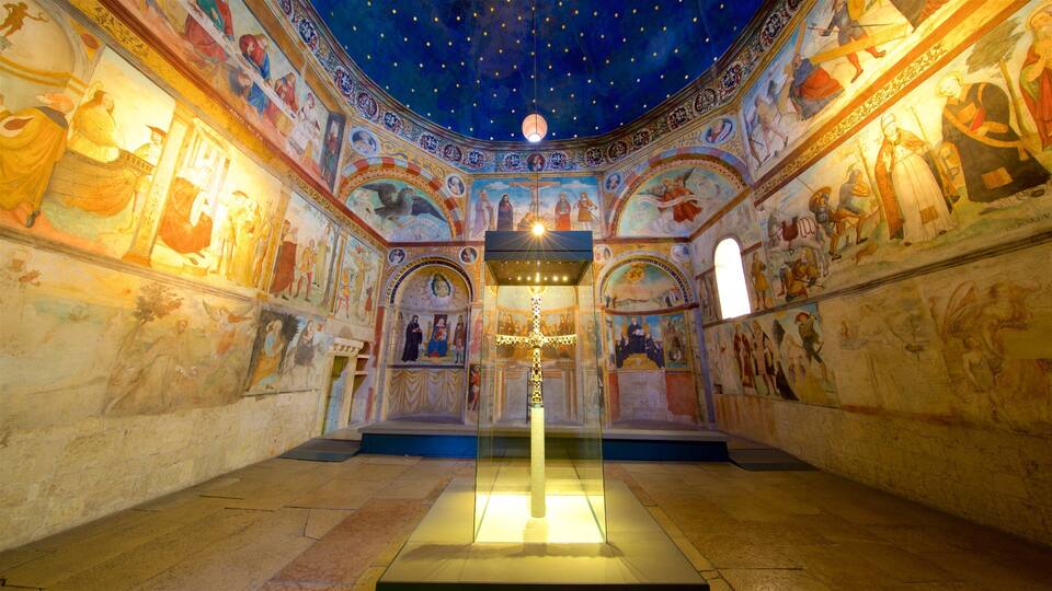 A church interior with a starry ceiling, detailed frescoes, and a central cross.