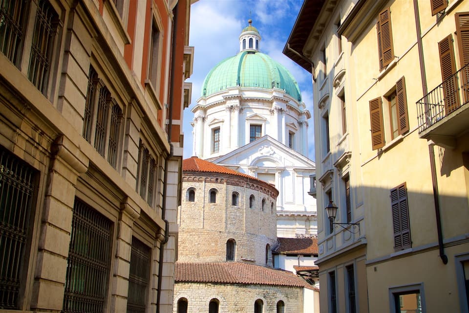 Eine enge Straße mit historischen Gebäuden, einer markanten Kuppel und einem Steinturm.