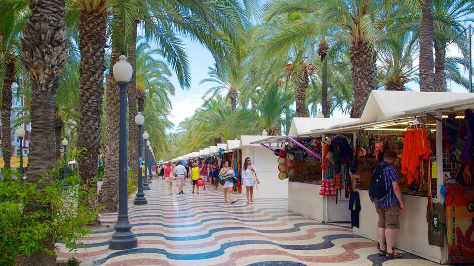 Una animada calle comercial bordeada de palmeras y puestos coloridos.