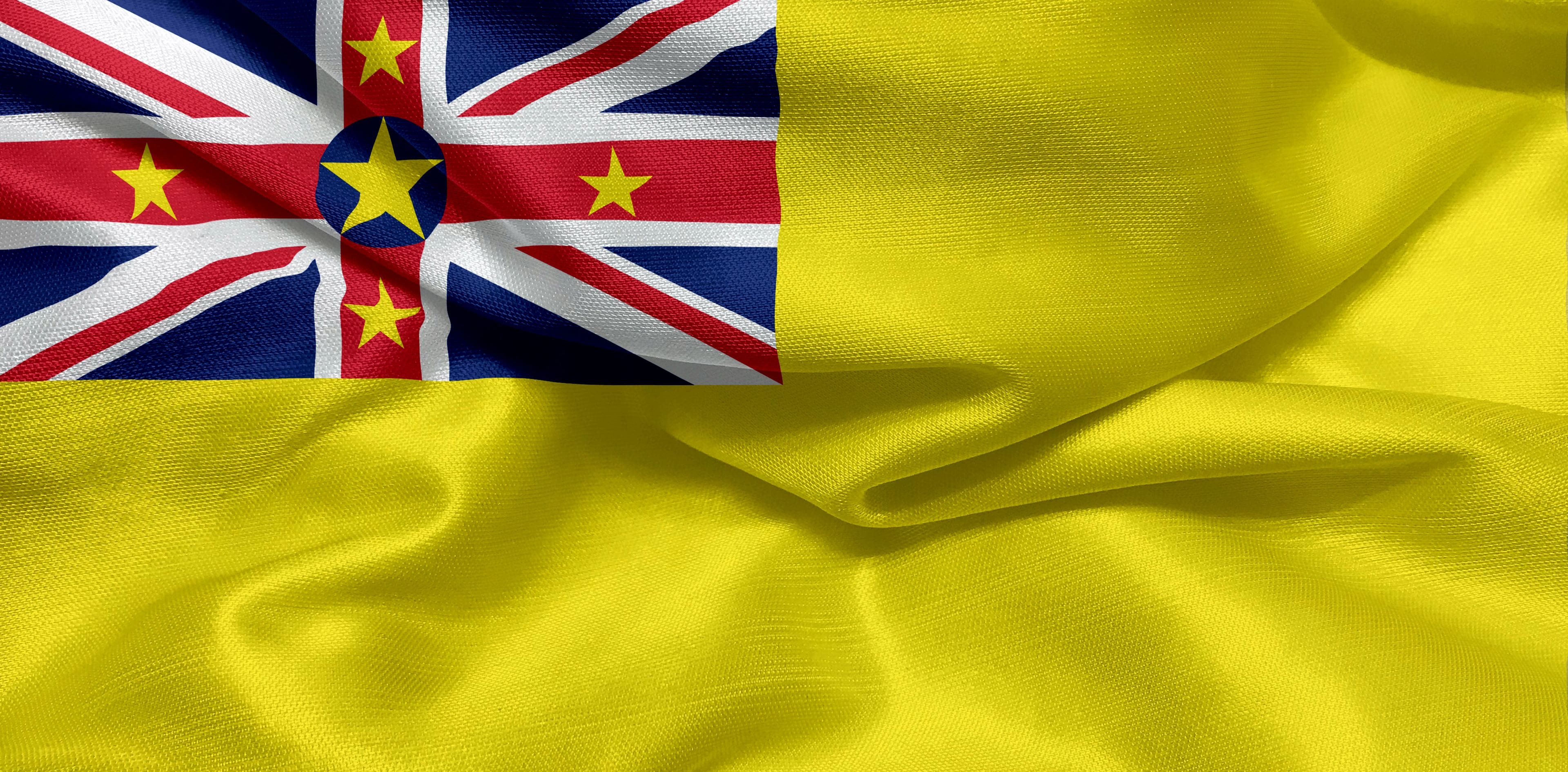 Una bandera con campo azul, cruz blanca, franjas rojas y blancas, y estrellas amarillas.