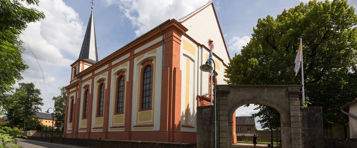 A historic building with a tall spire and a stone archway.