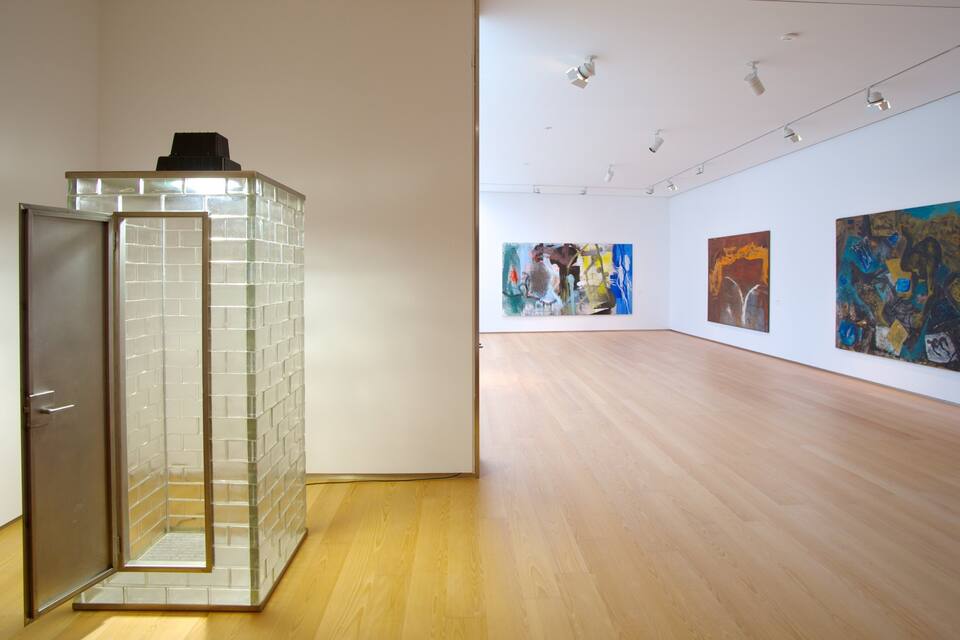 An art gallery with wooden floors and white walls.