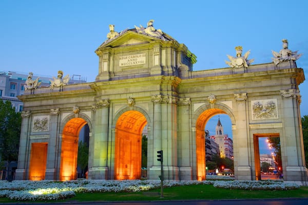 Puerta de Alcalá welches beinhaltet bei Nacht, Blumen und historische Architektur