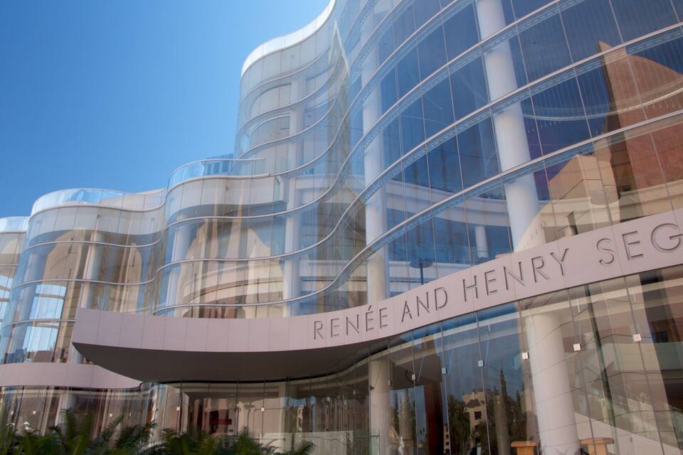 Ein modernes Gebäude mit gewölbten Glasschirmen und einer Beschilderung mit dem Schriftzug "Renee und Henry Seger".