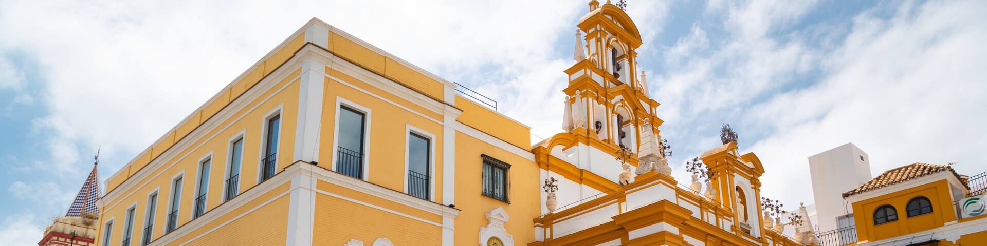 A yellow building with white trim and a bell tower.