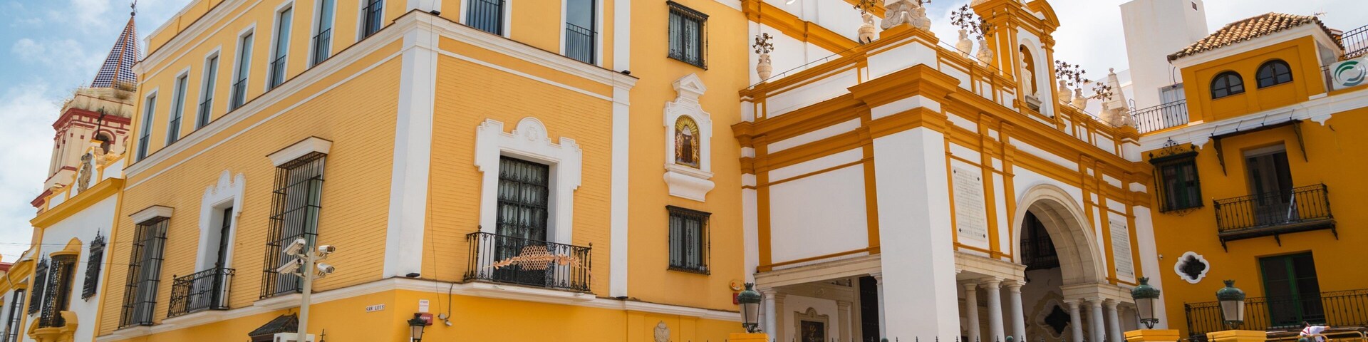 Un edificio amarillo con detalles blancos y una torre de campanas.