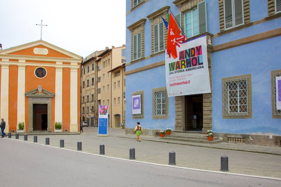 A street with a church and a blue building with a Andy Warhol exhibit.