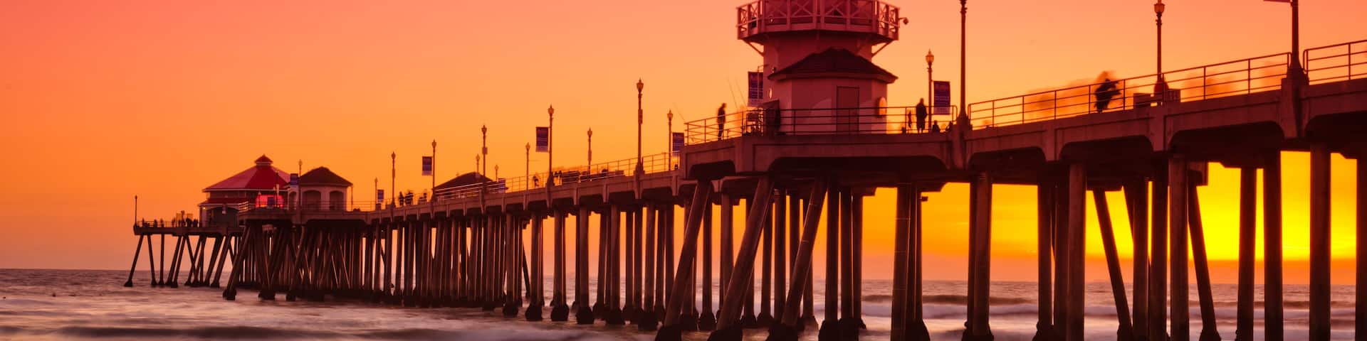 A wide shot of the Huntington Beach Pier during a bright red and orange sunset.; Shutterstock ID 95489323