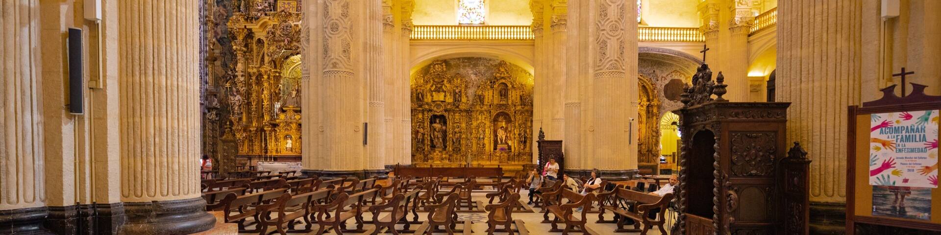 An ornate church interior with high ceilings, golden arches, and detailed altars.
