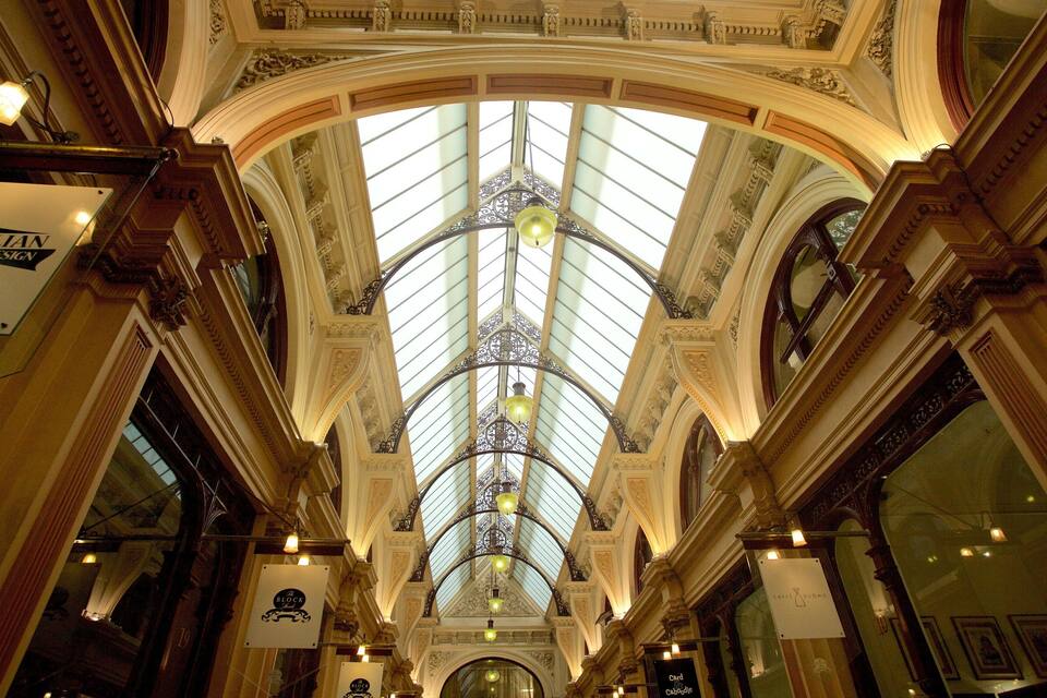 An ornate glass ceiling with intricate designs and chandeliers.