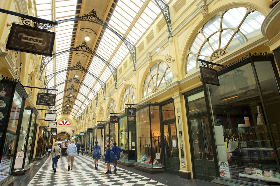 Un centre comercial interior amb un sostre alt i arquejat i un paviment d'escacs.