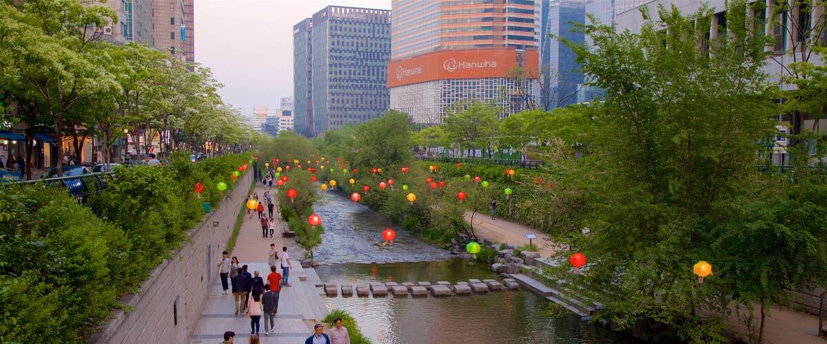 Cheonggyecheon showing a city and a river or creek as well as a small group of people